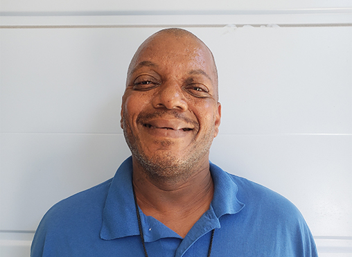 Antonio Smiling In A Blue Polo Shirt, Reflecting Hope, Resilience, And Personal Transformation Through The Midnight Mission