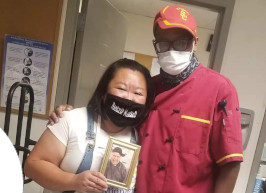 Volunteer Wendy Nguyen and James smiling together at The Midnight Mission community event in Los Angeles Skid Row serving those in need.