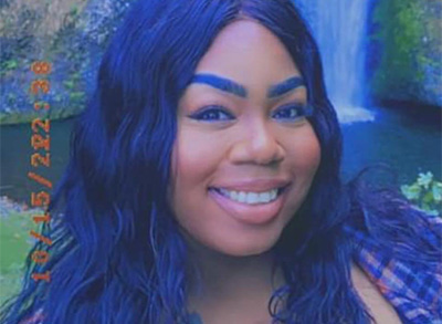 Aundria Smiles For The Camera Outdoors With A Waterfall In The Background And Long Dark Hair Framing Her Face