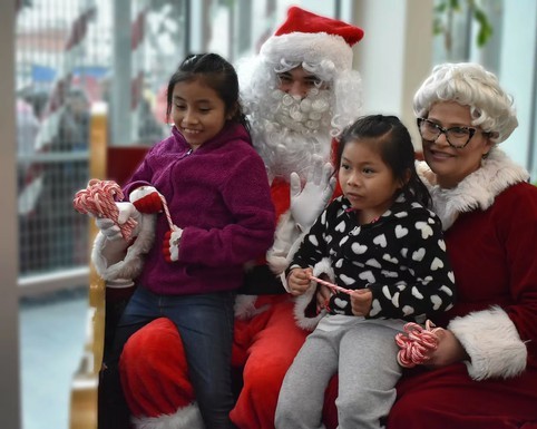 Kids with Santa and Mrs. Claus at The Midnight Mission holiday toy drive in Los Angeles.